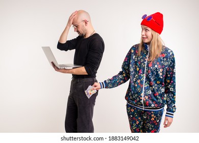 Stylish Woman Stealing Money From The Man Working At The Computer Over White Background