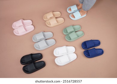 A stylish woman wearing cozy pants and colorful slippers stands against a warm brown background, showcasing a relaxed and comfortable look, perfect for casual indoor or loungewear fashion. - Powered by Shutterstock