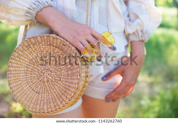 Stylish\
woman\'s outfit. Nature stylish top. Straw bag. White dress.Woman\
hands with fashionable stylish nude rattan bag and straw bag\
outside. Stylish young woman fashion\
details.