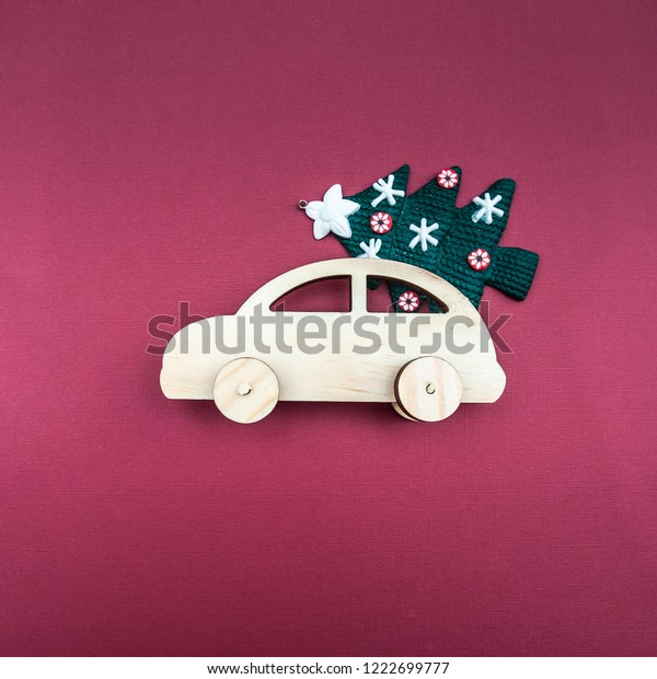 Stylish wooden car with a\
Christmas tree on a plain background. Minimalism, View from above,\
flat lay