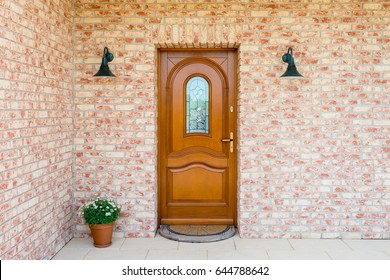 Stylish wooden front door in a detached house - embedded in a brick wall - entrance of a home