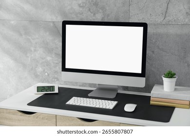 Stylish workplace with computer and black mousepad on white table indoors. Space for text