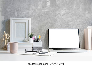 Stylish workplace with laptop computer, coffee cup, stationery and picture frame. - Shutterstock ID 2209045591