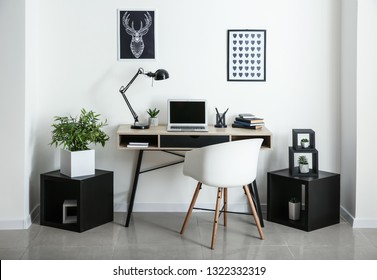 Stylish workplace with laptop in room - Powered by Shutterstock