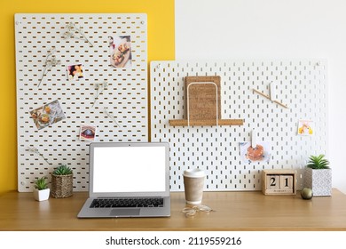 Stylish Workplace With Peg Board On Yellow And White Wall Background