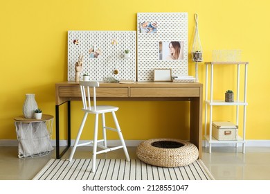 Stylish Workplace With Peg Board On Yellow Wall Background