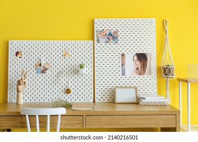 Stylish Workplace With Peg Board On Yellow Wall Background