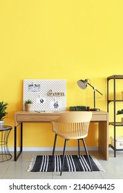 Stylish Workplace With Peg Board On Yellow Wall Background