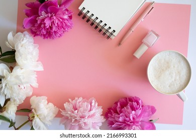 Stylish workspace with cup coffee, paper, laptop and pink peony flowers. Woman working table. Top view, flat lay, copy space.Pink peonies bouquet. Top view feminine background.Spring summer background