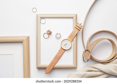 Stylish wristwatch, blank photo frame and rings on light background - Shutterstock ID 2029288334