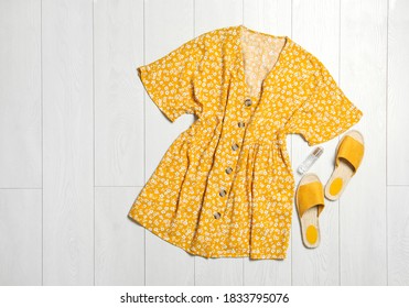 Stylish Yellow Dress, Perfume And Shoes On Wooden Floor, Flat Lay