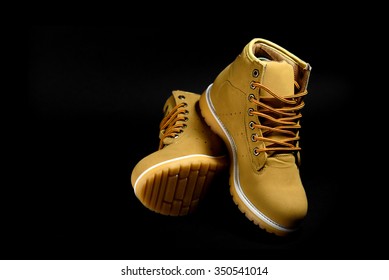 stylish yellow nubuck mens boots on black background, advertising concept - Shutterstock ID 350541014