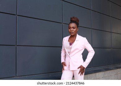 Stylish young african american girl wearing pink suit with bird brooch accessory. Female model wearing glamorous outfit. Stylish afro american woman posing outdoors. Concept of people and lifestyle. - Shutterstock ID 2124437846