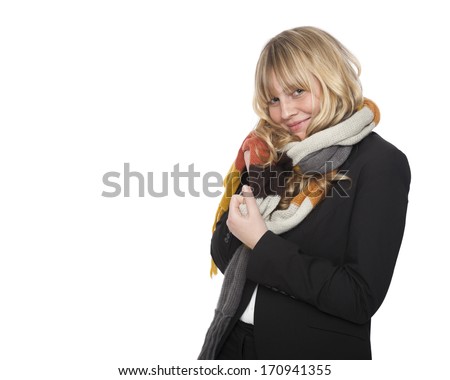 Stylish young blond woman in a winter scarf standing sideways smiling teasingly at the camera, isolated on white with copyspace