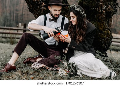 Stylish Young Couple Of Travelers. Family On A Walk In The Mountains Laid Out A Tent, Prepare Breakfast And Plan A Further Itinerary. Wedding In Georgia