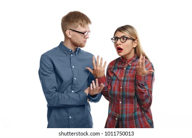 Stylish Young European Couple In Glasses Having Arguement In Studio: Emotional Blonde Girl With Fed Up Look, Feeling Tired And Stressed While Explaining Her Grumpy Bearded Husband Thar She Is Right