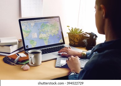 Stylish Young Girl Hipster Looking At Map On Laptop, Freelance And Planning Summer Travel Vacation Concept