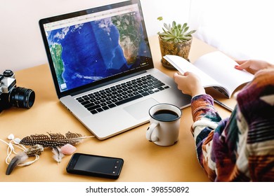 Stylish Young Girl Hipster Looking At Map On Laptop And Holding Notebook, Freelance And Planning Summer Travel Vacation Concept