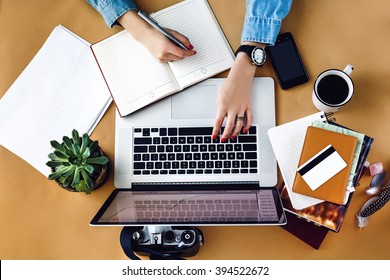 stylish young girl working  analytics holding pen on craft background with laptop and papers flat lay - Powered by Shutterstock