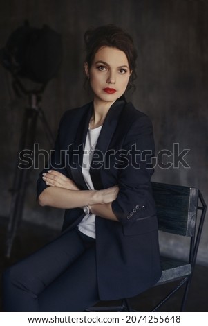 Stylish young girls in pantsuits pose in a photo studio.