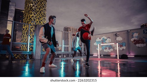 Stylish Young Man Dribbling, Passing Opponents Alone with a Ball on Wet Surface. Multiethnic Diverse Group of Friends Playing Soccer Outside on Rooftop Urban City Location at Sunset After Rain - Powered by Shutterstock