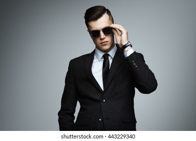 Stylish Young Man In Suit And Sunglasses. Business Style. Fashionable Image. Office Worker. Sexy Man Standing And Looking At The Camera