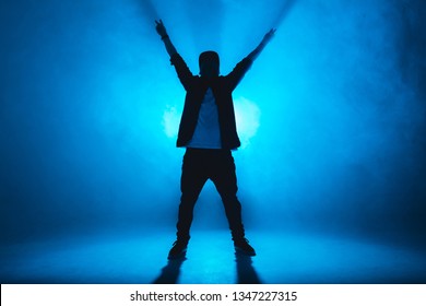 Stylish Young Man Wearing Trendy Streetwear Is Dancing Contemporary Street Dance On A Blue Studio Background