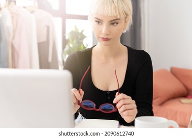 Stylish Young Woman Beauty Editor Of The Fashion Department   Of A Glossy Magazine Works At A Laptop In Red Glasses