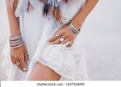 stylish young woman with boho accessories in short white dress outdoors close up