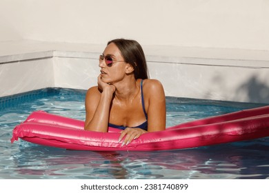 Stylish Young Woman Lounging Poolside in Pink - Powered by Shutterstock