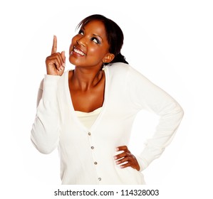 Stylish young woman pointing and looking up against white background