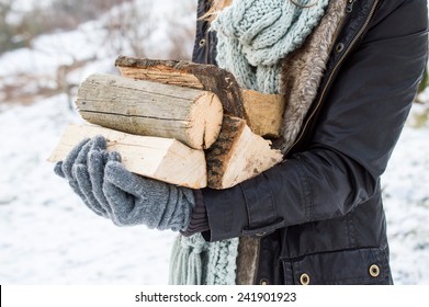 Stylish young woman posing with wooden logs for bonfire