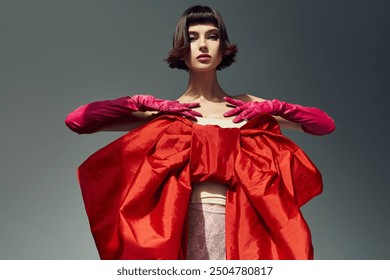 A stylish young woman showcases a bold red dress featuring an oversized bow in an artistic pose. - Powered by Shutterstock