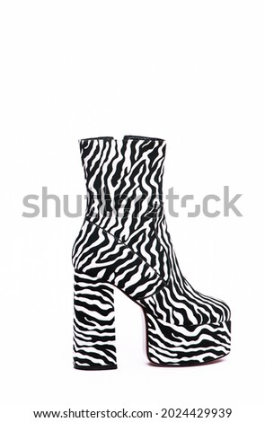 Stylish zebra boots shoes in white space. Minimal still life scene. Sale and shopping trendy concept