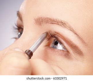 Stylist is applying eyeshadow for young girl