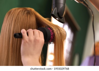 Stylist blow drying woman's hair in salon - Shutterstock ID 1955029768