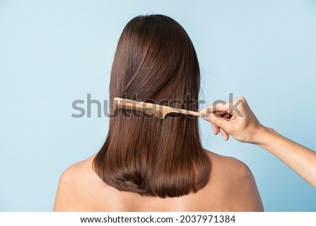 Stylist combing a woman#39;s hair