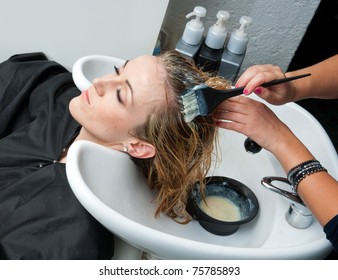 Stylist Putting Color On Woman Hair In Salon Pool