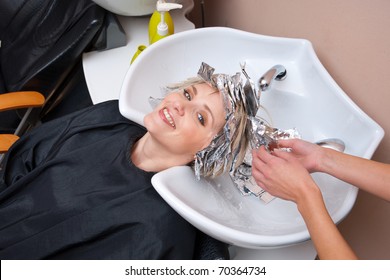 Stylist Removing Coloring Foil From Woman Hair