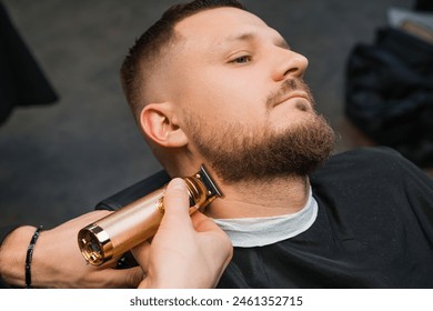 Stylist uses trimmer and comb working with client beard in barbershop closeup. Barber cuts hair on man face with machine in grooming salon - Powered by Shutterstock