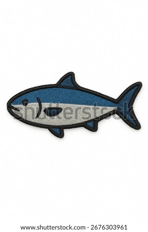 A stylized embroidered patch of a fish. The design features a sleek body with blue and white stripes and a black outline. The patch has a noticeable thread texture, giving it a handcrafted feel.