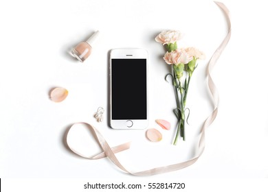 Stylized Feminine Flatlay With Nail Polish, Flowers, Petals, Ribbon And Smart Phone Mock Up Isolated On White Top View. Woman Accessories From Above