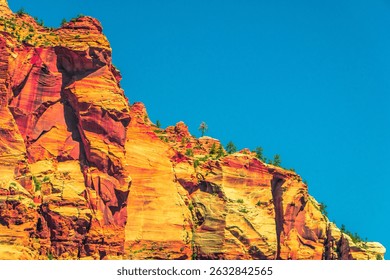 Stylized photo of dramatic sandstone cliffs in Zion National Park with surreal colors and bold contrast against deep blue sky. Artistic interpretation of iconic desert landscape.