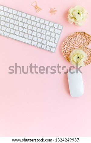 Stylized, pink women's home office desk. Workspace with computer, bouquet ranunculus and roses, clipboard, feminine golden fashion accessories isolated on pink background. Flat lay. Top view.