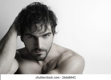 Stylized Portrait Of Masculine Attractive Young Shirtless Man With Beard Against White Background