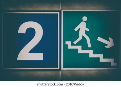 Stylized signs "evacuation exit" with the figure of a little white man and "number two" with vignette