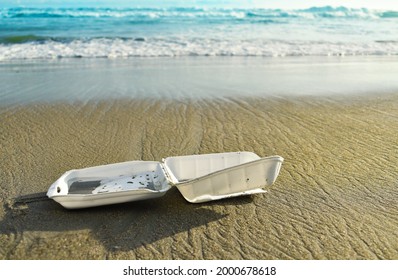 Styrofoam disposable food box on the beach, pollution, waste on sand beach