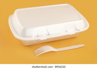 Styrofoam Take-out Food Container And Plastic Fork On A Yellow Background