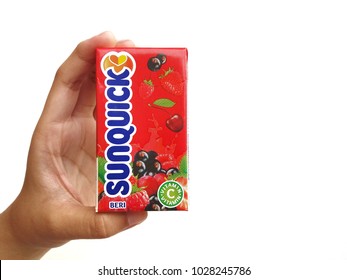 Subang Jaya , Malaysia - 15 February 2018 : Hand hold a box packet of Sunquick liquid flavor Berries over white background. Sunquick is a product of CO-RO A/S a Danish company.