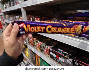 Subang Jaya, Malaysia - 30 April 2018 : Hand Hold A Packet Of NESTLE Violet Crumble Chocolate Bar In The Supermarket.